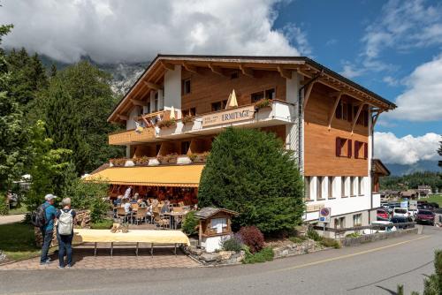 a building with people standing in front of it at Typically Swiss Hotel Ermitage in Kandersteg
