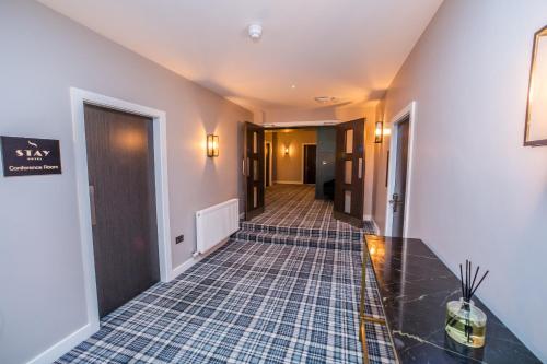 a hallway with a tile floor in a hotel at Stay Hotel in Huddersfield