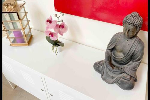 a statue of a buddha sitting on a wall at baleal penthouse in Ferrel