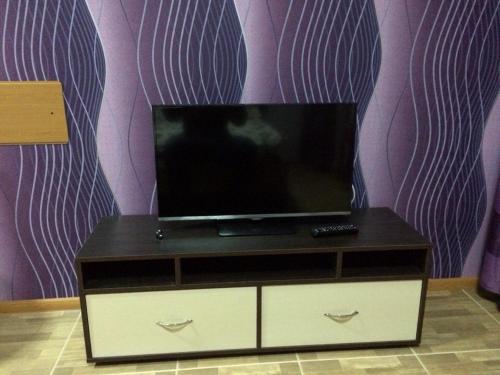 uma televisão em cima de uma cómoda num quarto em ShangHai Hotel em Konotop