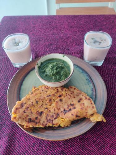 a plate of food with a bowl of guacamole and a bowl at Trippme Rishikesh, formerly The Sweven in Rishīkesh