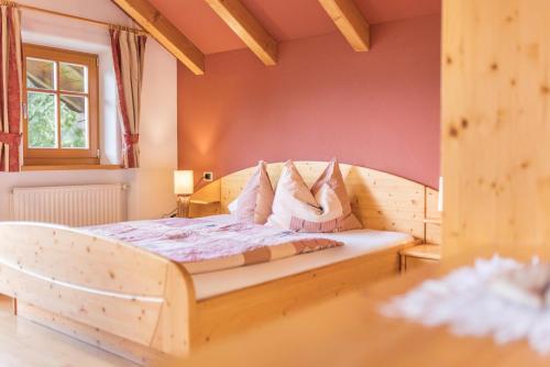 a bedroom with a wooden bed in a room at Oberplunerhof - Fewo Kronplatz in Chienes