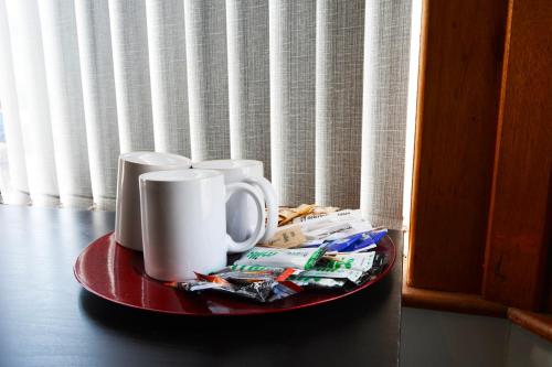 einen Teller mit zwei Kaffeetassen auf dem Tisch in der Unterkunft Old Swan Guest House in Liverpool