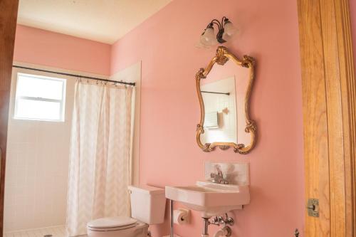a pink bathroom with a sink and a mirror at The Ann Stevens House in Cassadaga