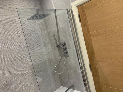 a shower with a glass door and a toilet in a bathroom at Stunning Central Alnwick Two Floor Apartment in Alnwick