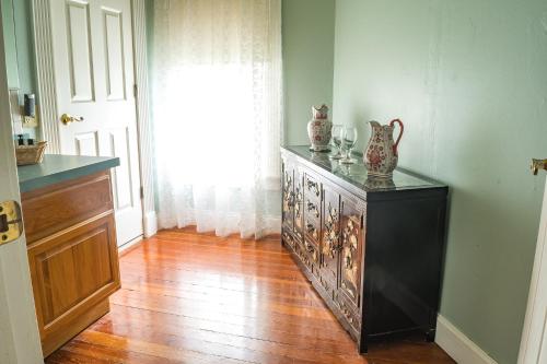 a room with a cabinet with vases on top of it at The Ann Stevens House in Cassadaga