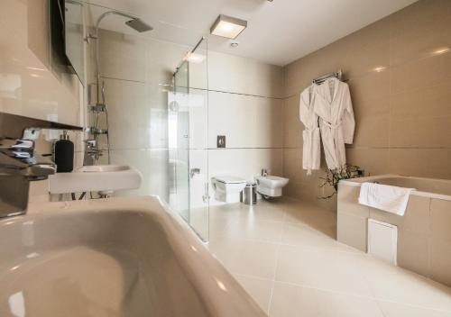 ein Badezimmer mit Badewanne, Waschbecken und Toilette in der Unterkunft Penthouse Poiana Brașov B44 in Poiana Brașov