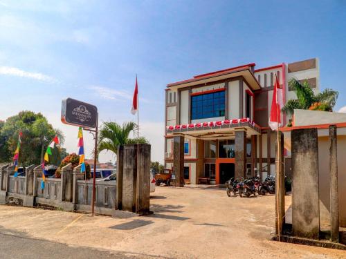 a hotel with flags in front of a building at Collection O 90564 Hotel Merangin Syariah in Bangko