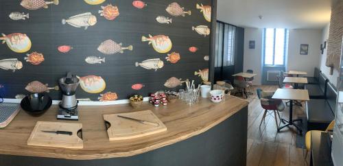 un mostrador en una habitación con una pared cubierta de marisco en Logis Hôtel Restaurant La Châtellenie, en Availles-Limouzine