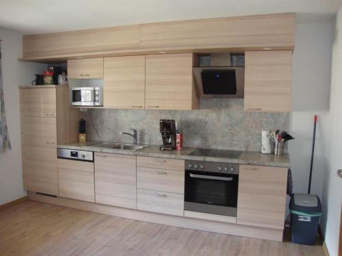 eine Küche mit Holzschränken und einem Waschbecken in der Unterkunft Haus am Bühel in Gaschurn