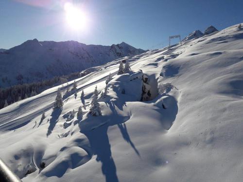 a snow covered mountain with the sun in the background at Haus am Bühel in Gaschurn