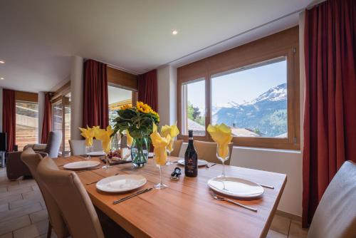 a dining room table with a view of a mountain at Chalet Am Acher 3 in Wengen