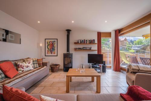 a living room with a couch and a table at Chalet Am Acher 3 in Wengen