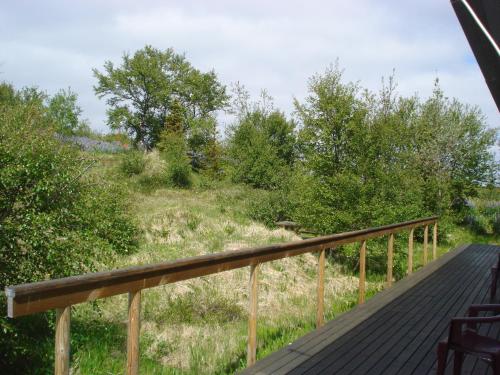 a deck with a view of a field at Vinland Guesthouse in Egilsstadir