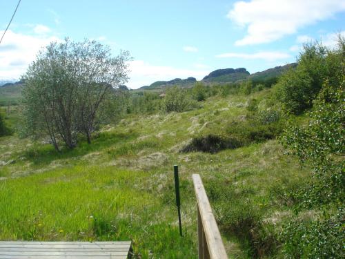 a grassy hill with a wooden fence in a field at Vinland Guesthouse in Egilsstadir