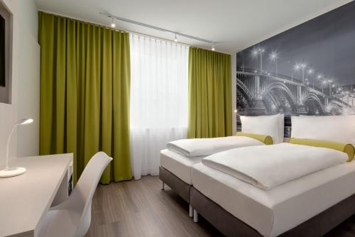 two beds in a room with green curtains at Super 8 by Wyndham Chemnitz in Chemnitz