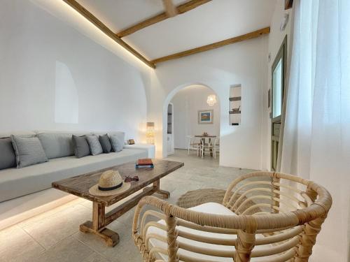 a living room with a couch and a table and chairs at Kallichoron Art Boutique Hotel in Astypalaia Town