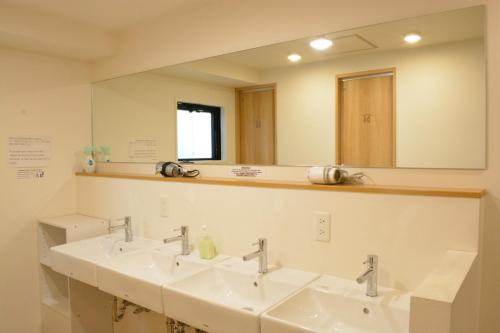 a bathroom with three sinks and a large mirror at 04 village Namba - Vacation STAY 17857v in Osaka