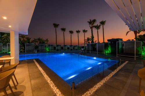 a swimming pool on a building with palm trees at Tasia Maris Sands (Adults Only) in Ayia Napa