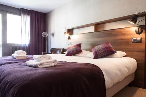 a hotel room with two beds with towels on them at Pointe Isabelle in Chamonix-Mont-Blanc