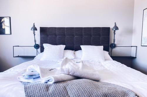 a bed with white sheets and towels on it at Bongska Huset in Abbekås