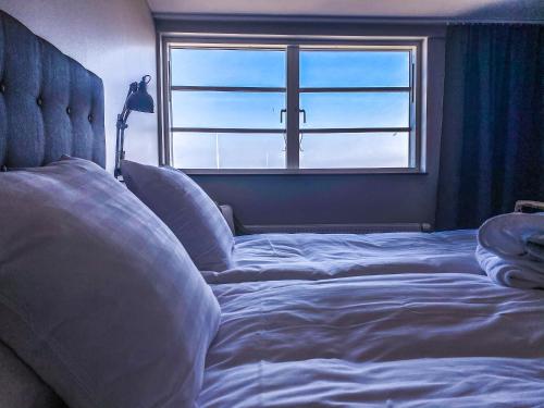 a bedroom with a large bed with a window at Bongska Huset in Abbekås