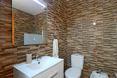 Un baño con lavabo, inodoro y espejo. en 051 - Costa Hispania II 094 - comfortHOLIDAYS, en Gran Alacant