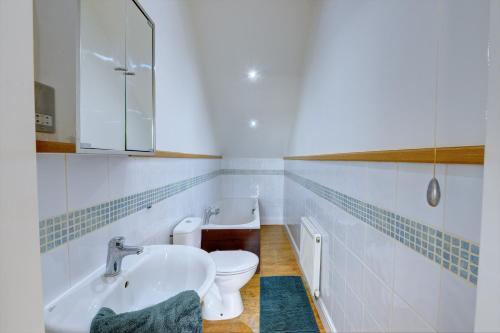 a white bathroom with a toilet and a sink at Leamington Spa Warwick Place Apartments in Leamington Spa