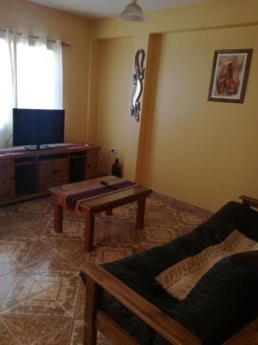 uma sala de estar com uma mesa e uma televisão em Ivon em Neuquén