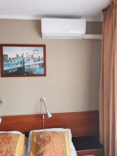 ein Schlafzimmer mit einem Bett, einer Lampe und einem Bild an der Wand in der Unterkunft Willa Solan in Ciechocinek
