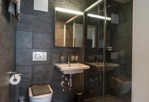 a bathroom with a sink and a toilet and a mirror at HITrental Central Station Apartment in Zürich