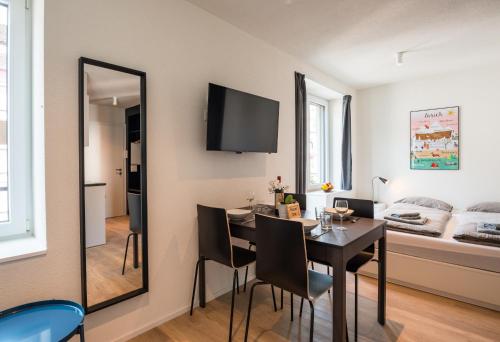 a dining room with a table and a mirror at HITrental Central Station Apartment in Zürich