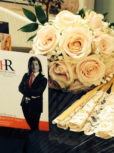 a poster of a woman and a bouquet of roses at Hotel Roma Aparthotel in Malcesine