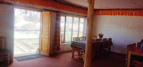 a dining room with a table and a large window at Shyok Camp - Nubra in Nubra