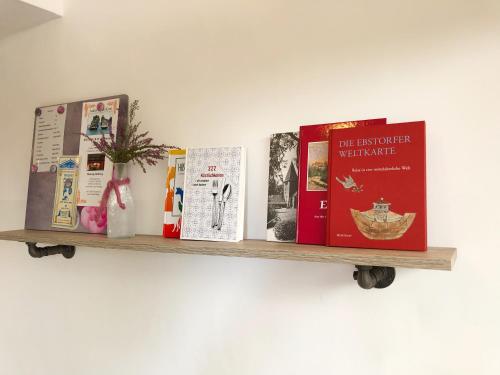 four books on a shelf on a wall at Christianes Apartment - Ebstorf in Ebstorf