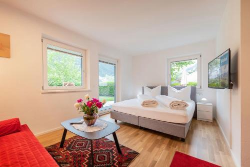 1 dormitorio con cama, mesa y ventanas en Mandelbaum Ferienwohnung, en Neustift im Stubaital