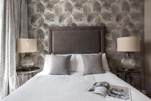 ein Bett mit zwei Lampen und eine Zeitschrift drauf in der Unterkunft Luxury 5* Heart of The City, Fabulous Views in Belfast