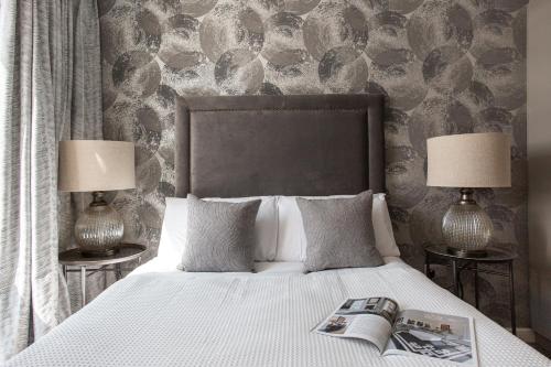 un letto con due lampade e una rivista sopra di Luxury 5* Heart of The City, Fabulous Views a Belfast