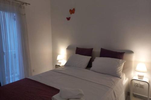 een slaapkamer met een groot wit bed met 2 lampen bij Casa Bianca in Kalymnos