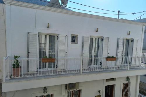 een wit gebouw met een balkon met planten erop bij Casa Bianca in Kalymnos