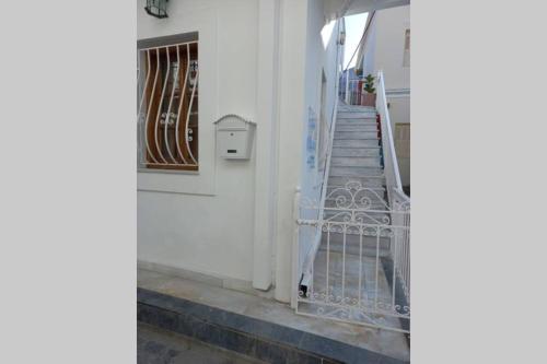 eine Treppe mit einer weißen Tür und einem Treppengeländer in der Unterkunft Casa Bianca in Kalymnos