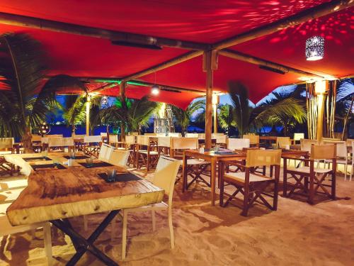 a restaurant with tables and chairs under a red tent at Hommage Hotel & Residences in Baie Nettle
