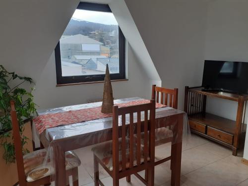 a dining room with a table and chairs and a window at Departamento Centro Ushuaia in Ushuaia