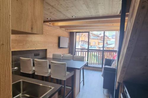 a kitchen with a table and chairs and a window at Val Thorens - SILVERALP - Duplex avec 3 chambres in Val Thorens