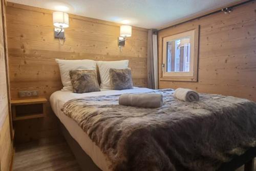 1 dormitorio con 1 cama grande en una habitación de madera en Val Thorens - SILVERALP - Duplex avec 3 chambres, en Val Thorens