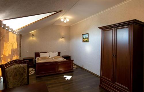 a bedroom with a bed and a table and a chair at Forest club Sherwood in Uman