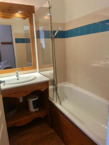 une salle de bain avec un lavabo, une baignoire et un miroir dans l'établissement CHAMROUSSE-SPORT&DETENTE appartement 6 couchages avec superbe vue, à Chamrousse