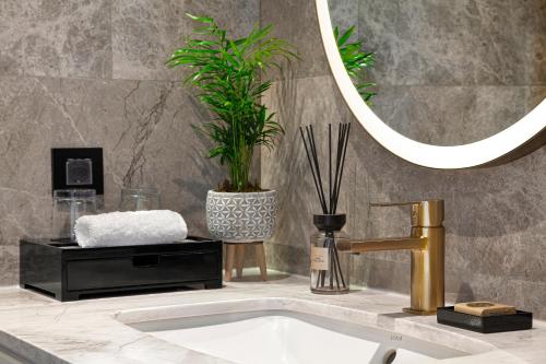 a bathroom sink with a gold faucet and a mirror at Wanda Vista Istanbul in Istanbul