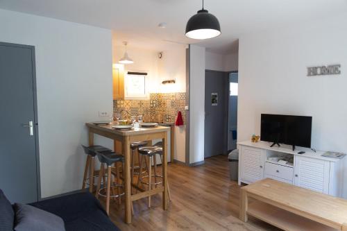 eine Küche und ein Wohnzimmer mit einer kleinen Küche und einem Tisch in der Unterkunft FONTANES in Niort