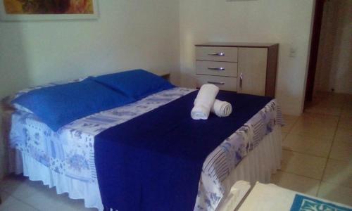 Una cama con dos toallas enrolladas. en Pousada Território da Paz, en Garopaba